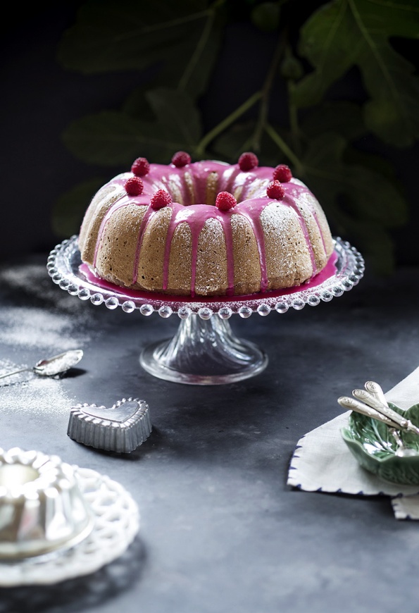 A cake with pink icing  looking dark and moody